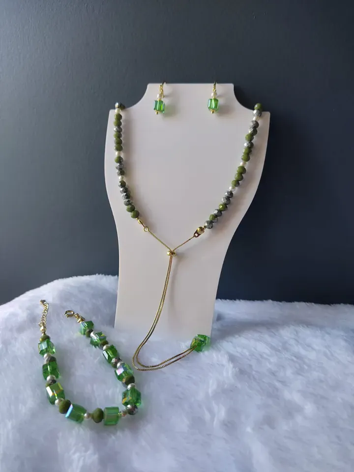 Colar gravatinha com contas verdes, brincos e pulseira de cristais verdes em cubo, em um busto branco