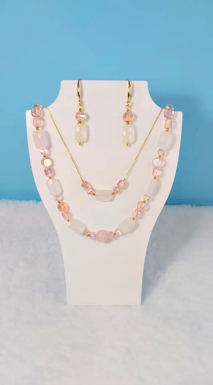 Colar de duas voltas e brincos com pedras rosa-claro e cristais rosa, em um busto branco